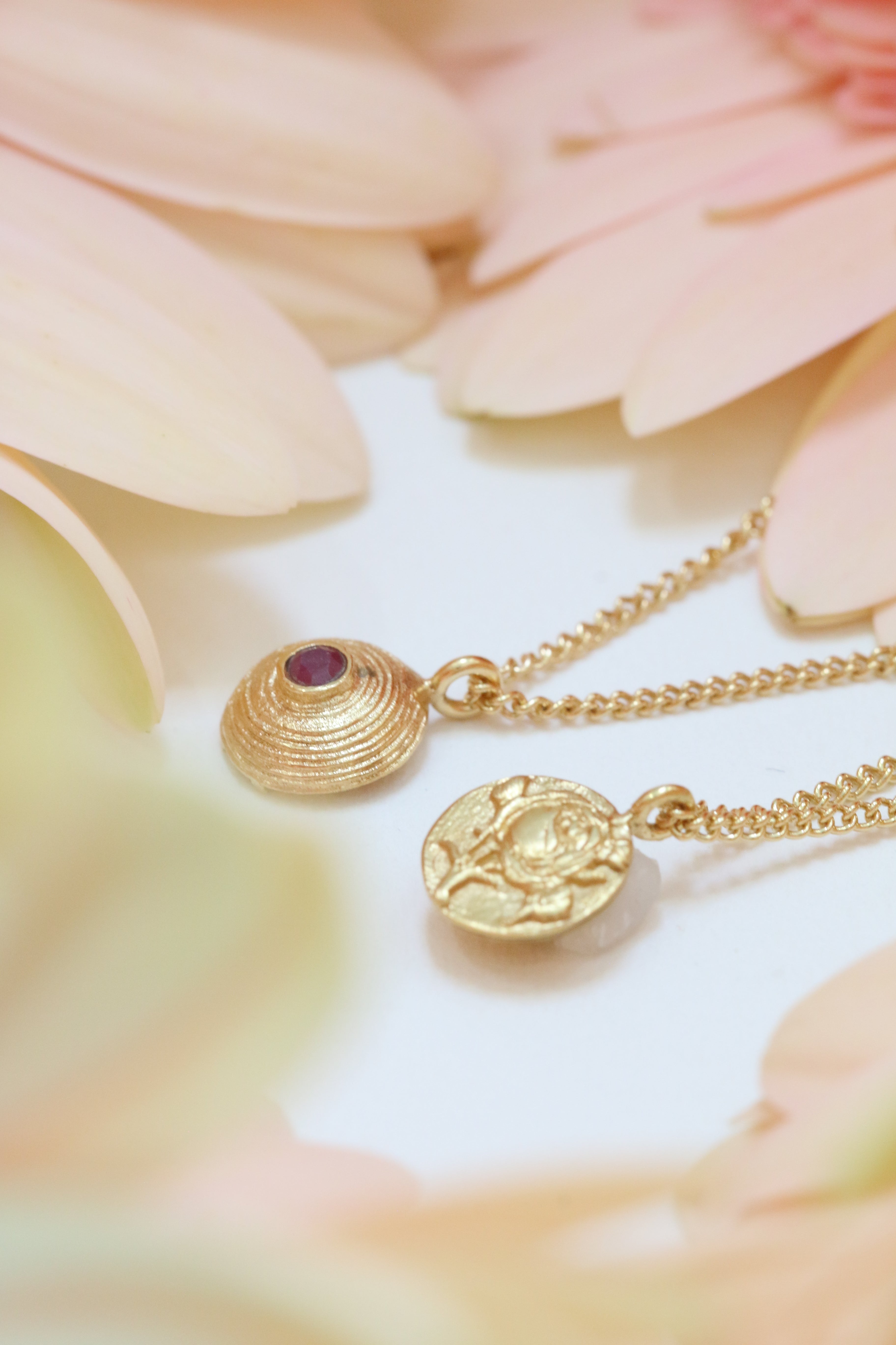 Mother’s Day Gift Guide: Gold Rose and ruby reversible necklace surrounded by flowers. Ethical handmade necklace jewelry for mom
