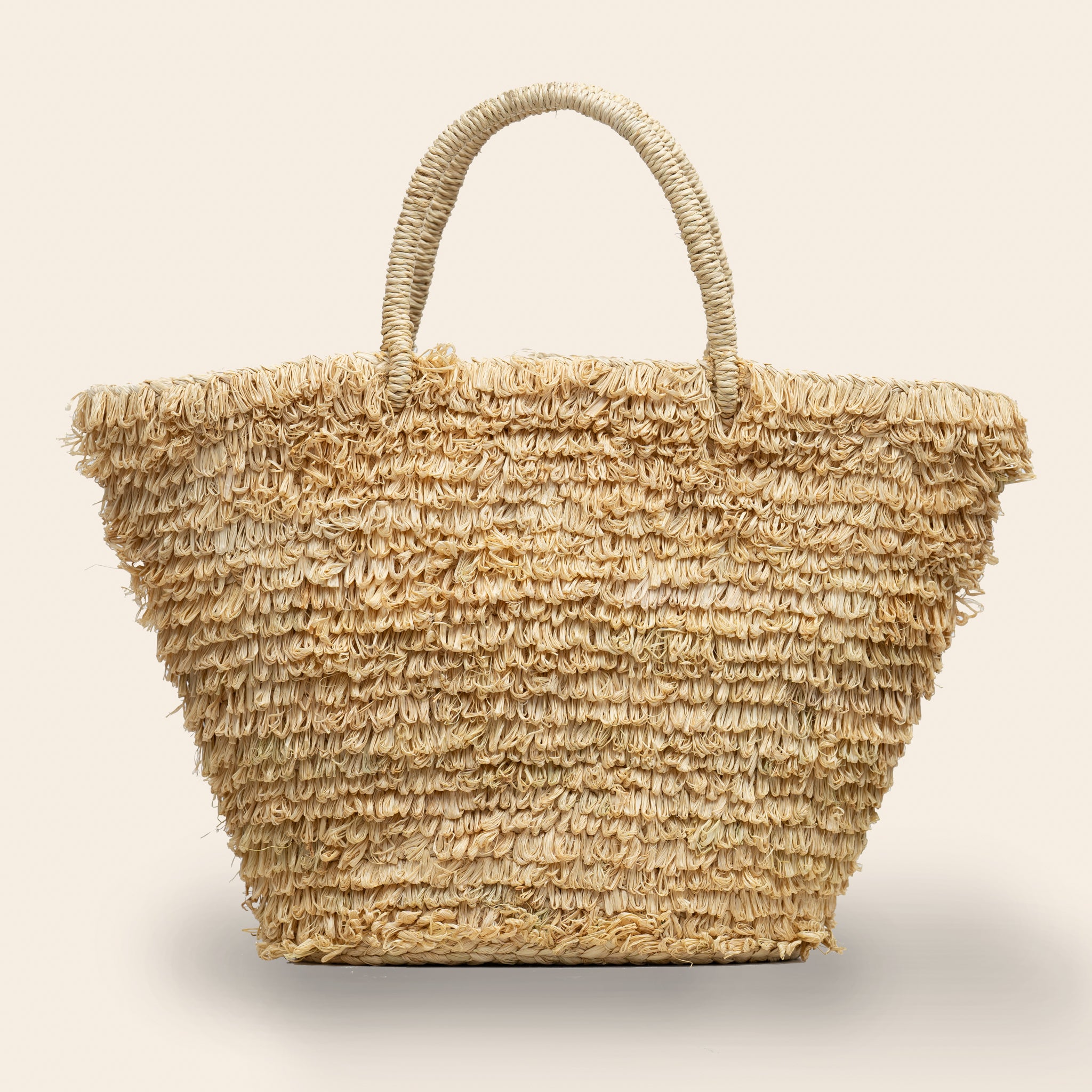 Natural Woven straw bag with a loop textured surface handmade in Rwanda through a fair trade partnership