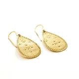 Handmade Gold vermeil teardrop earrings with intricate designs handstamped by artisans in mexico on a hook for wear, close up